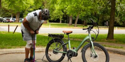 cyclist checking tire pressure gauge road bike